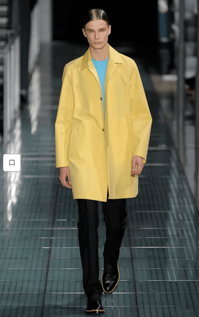 Model walks a Colville Spring 21 show wearing a yellow jacket with a cyan-like creamy blue top underneath.