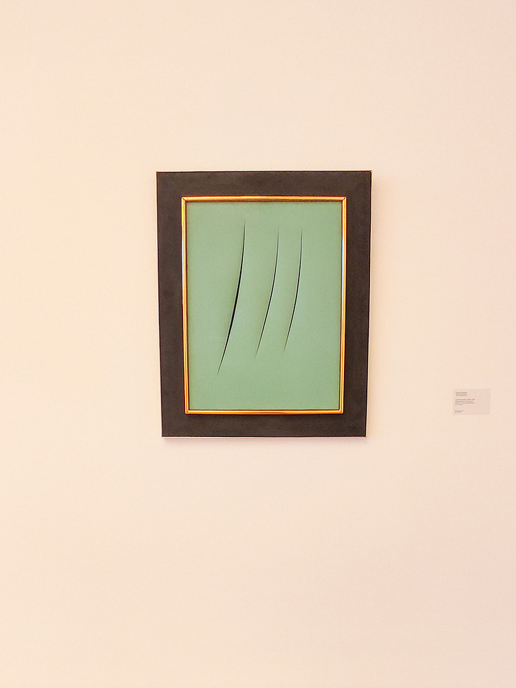 Green paper artwork with three lines cut in the center and framed with black and gold frame against a white wall in Ludwig Museum. Artwork by Lucio Fontana called Concetto spaziale: Attese, 1961