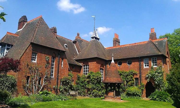 The Red House by William Morris, which is an architecture building from the arts and crafts movement. Building is composed of red brick and surrounded by greenery