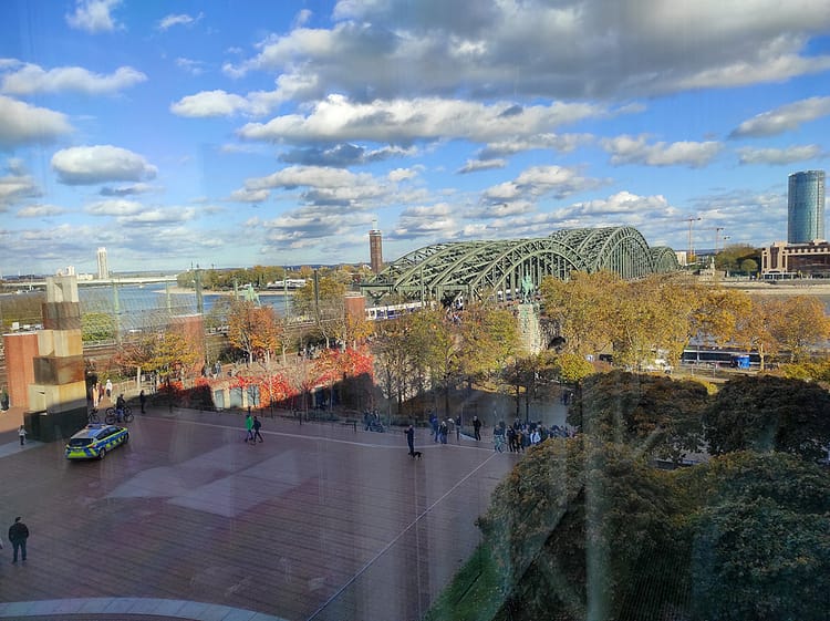 View through window from an upper floor within Museum Ludwig, View is overlooking Hohenzollern Bridge & River Rhine.