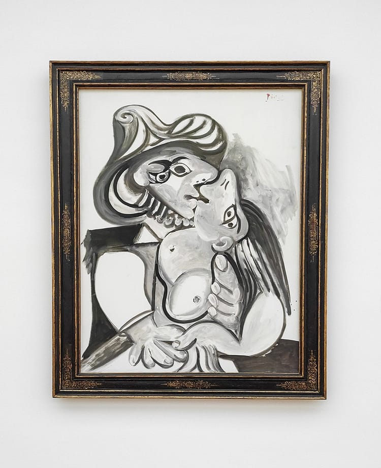 Black and white framed image of kissing man and woman in cubism style artwork by Picasso. On display against a white wall in Ludwig Museum.