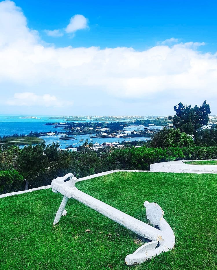 White Anchor on green grass at Gibb's Hill Lighthouse, Bermuda. Overlooking the island and sea.